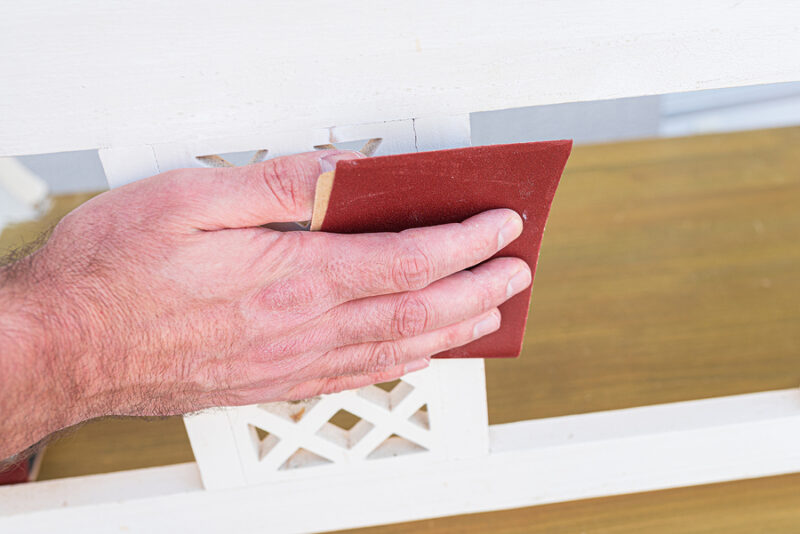 Close-up Of Person Sanding Piece Of Wooden Furniture Using Sandp
